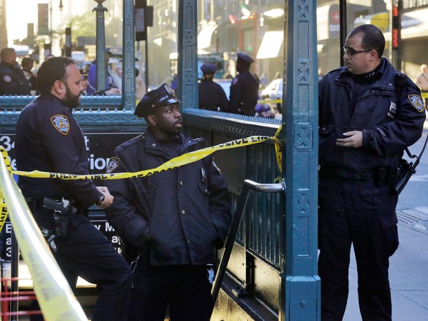 Policiais do Departamento de Polícia de Nova York investigam um tiroteio na estação de metrô da 35th rua com a oitava avenida em Nova York, EUA. Segundo as autoridades, três pessoas foram baleados e uma morreu. Nenhum suspeito foi preso (Foto: Mark Lennihan/AP)