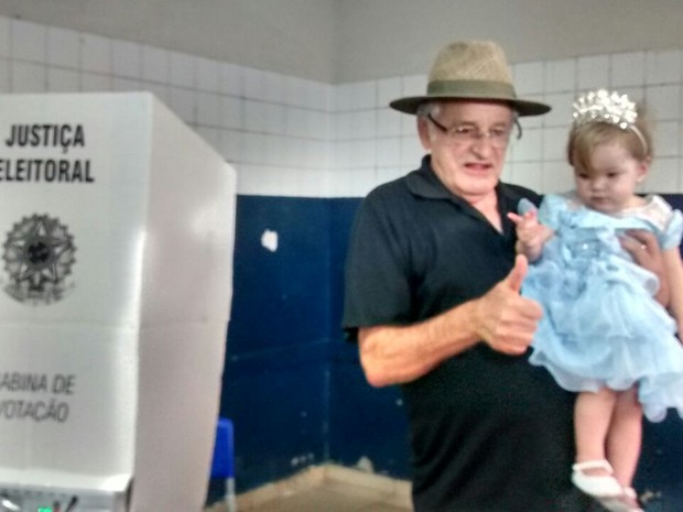 Candidato a prefeito de Ipatinga, Sebastião Quintão (PMDB), votou com a filha no colo (Foto: Patrícia Belo/ G1)